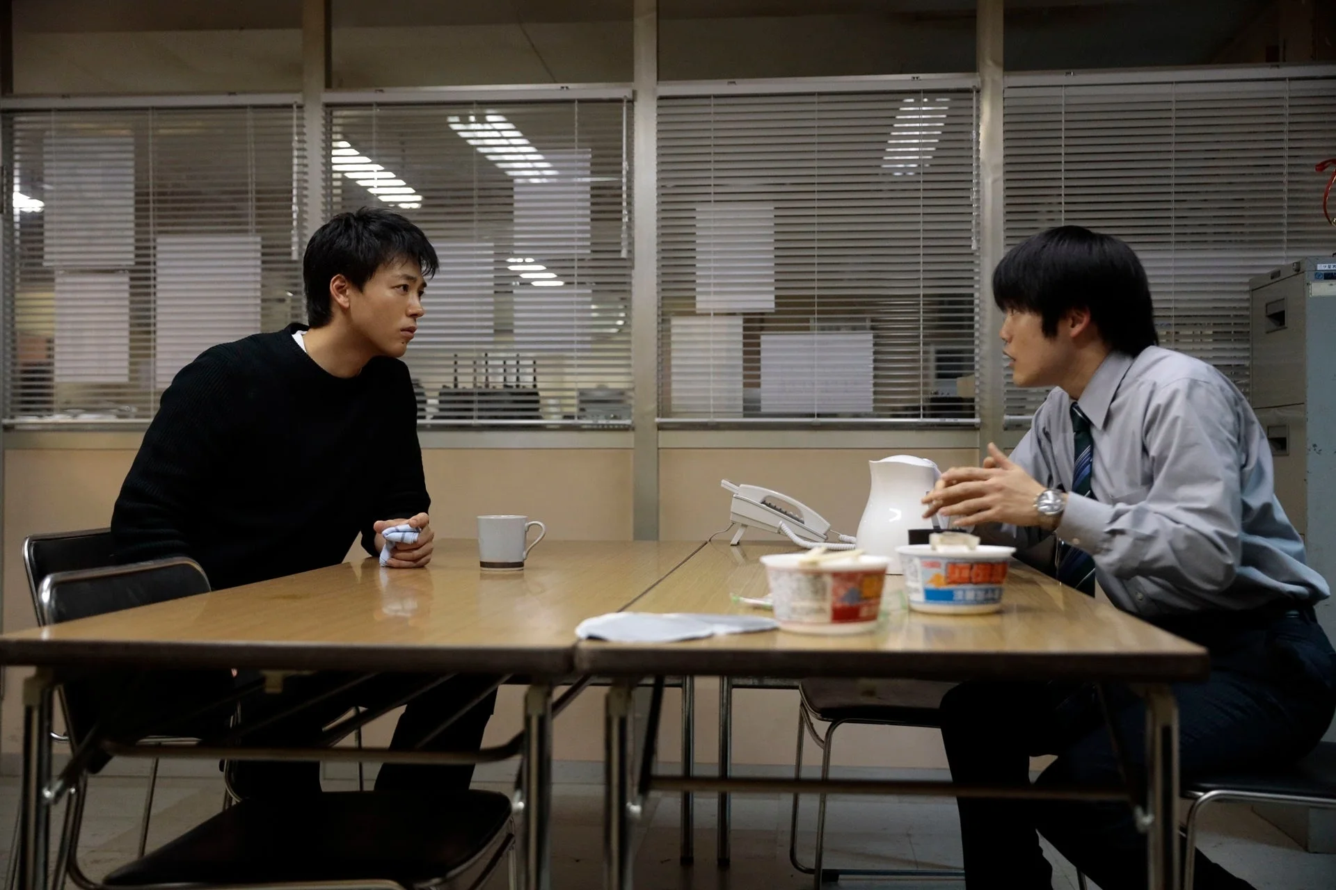 オフィスのような場所で話し合う二人の男性