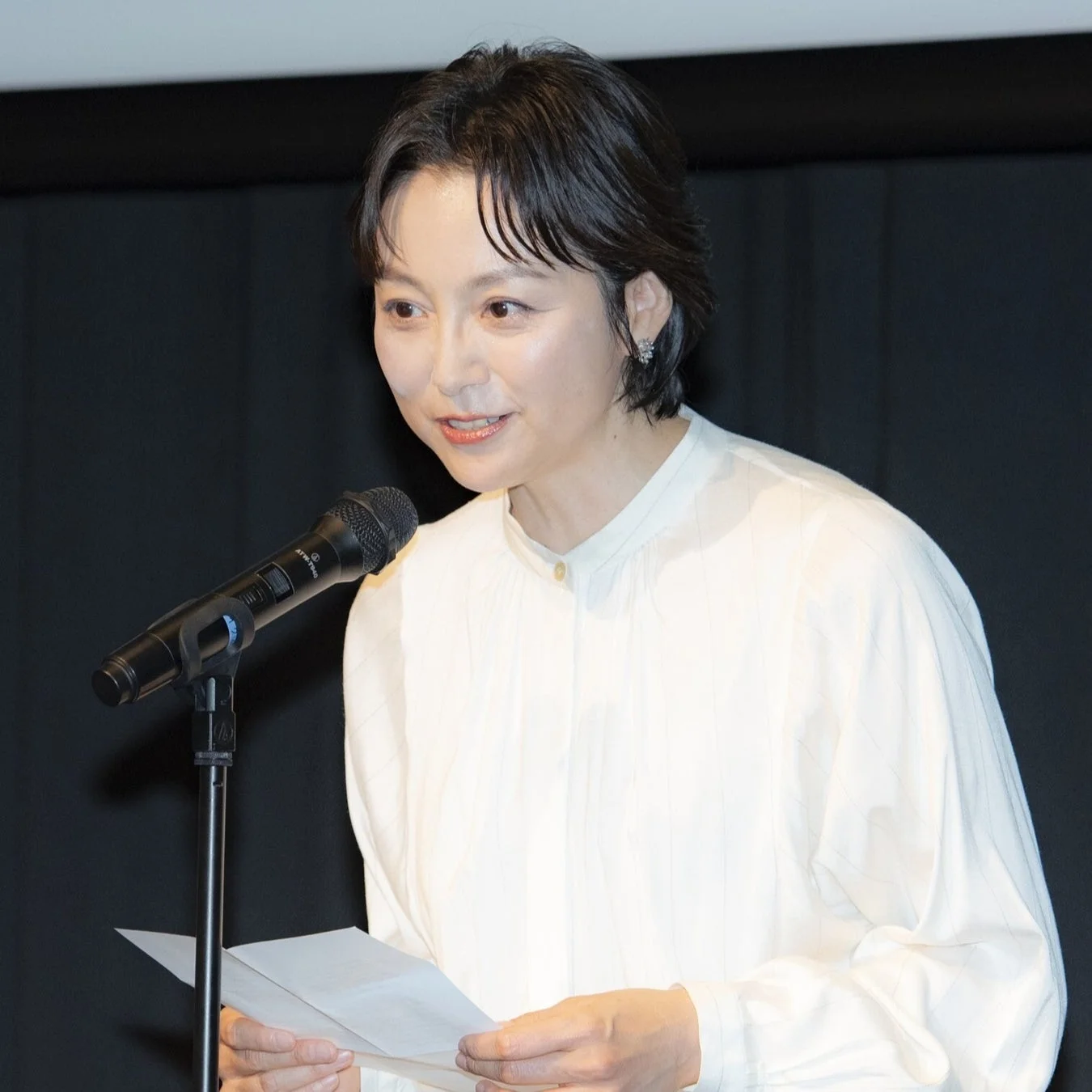 マイクに向かって話す女性