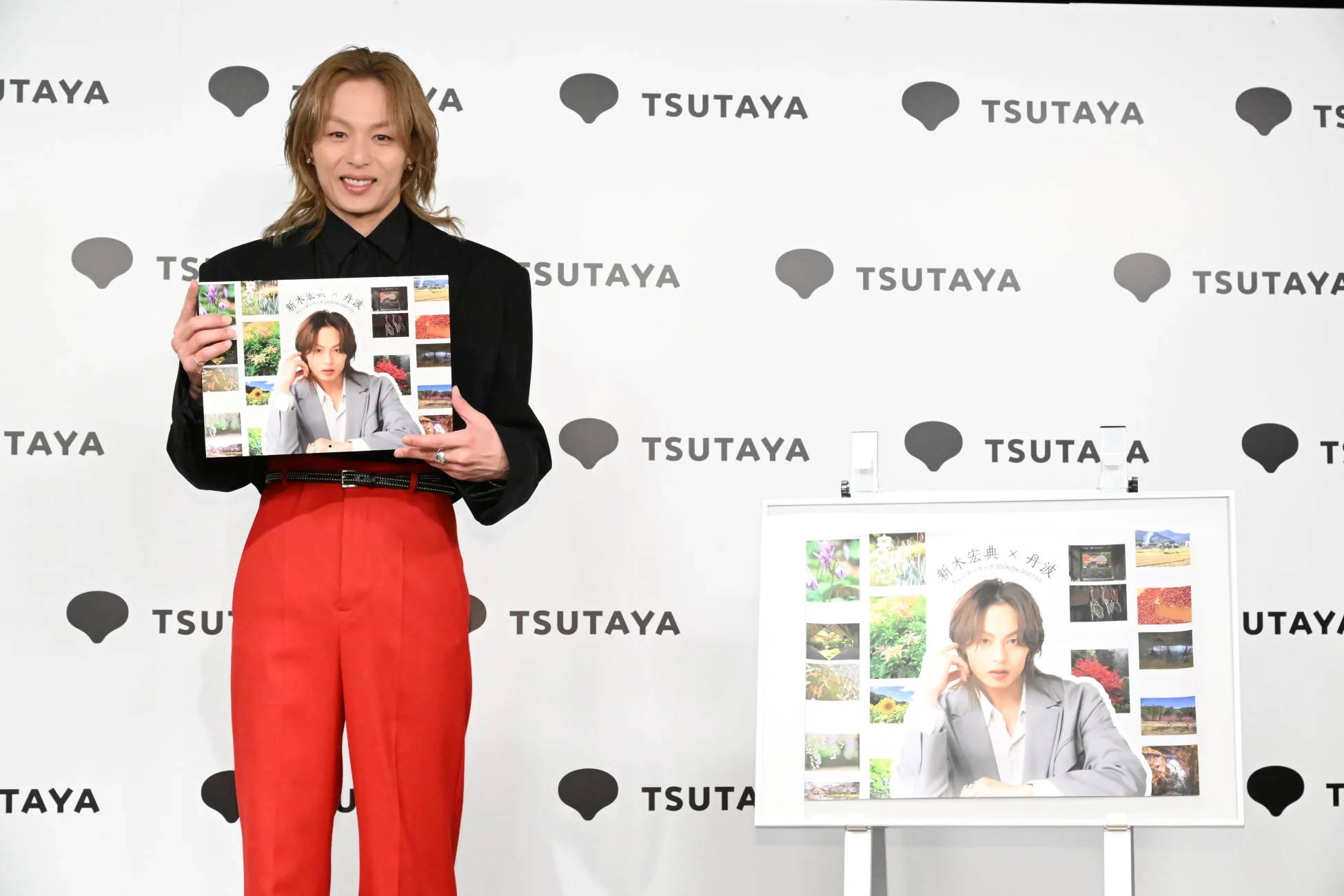 カレンダーブックのパネルと共に笑顔の新木宏典さん