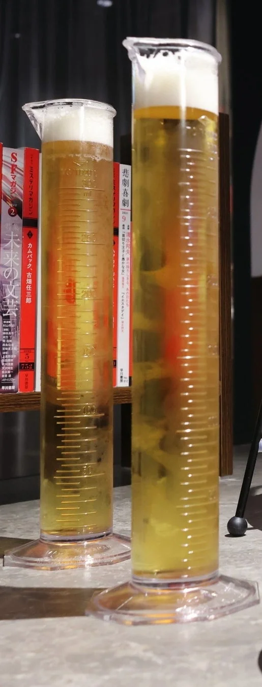 二つのメスシリンダーにビールが注がれている