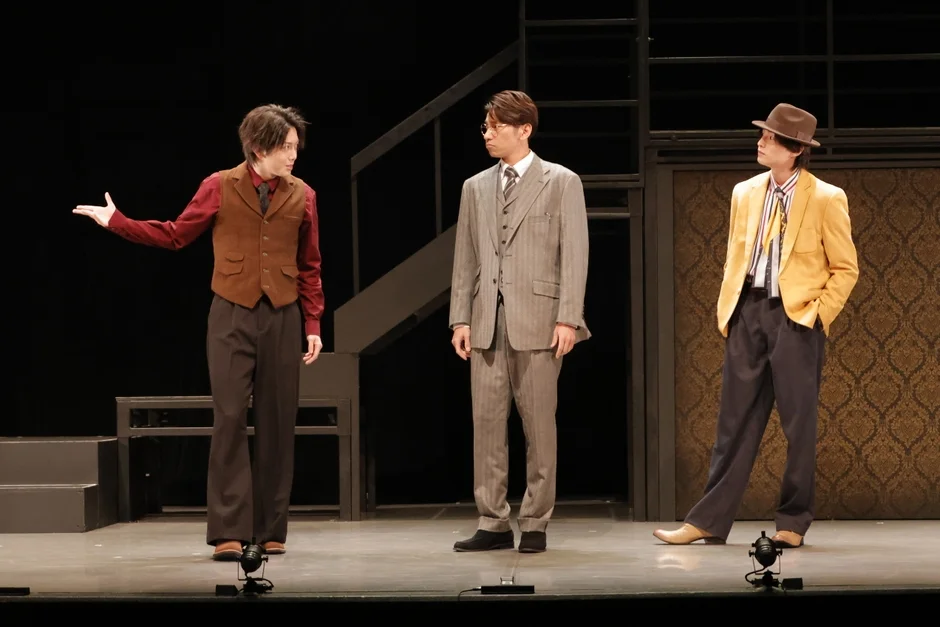 舞台で演技する3人の男性