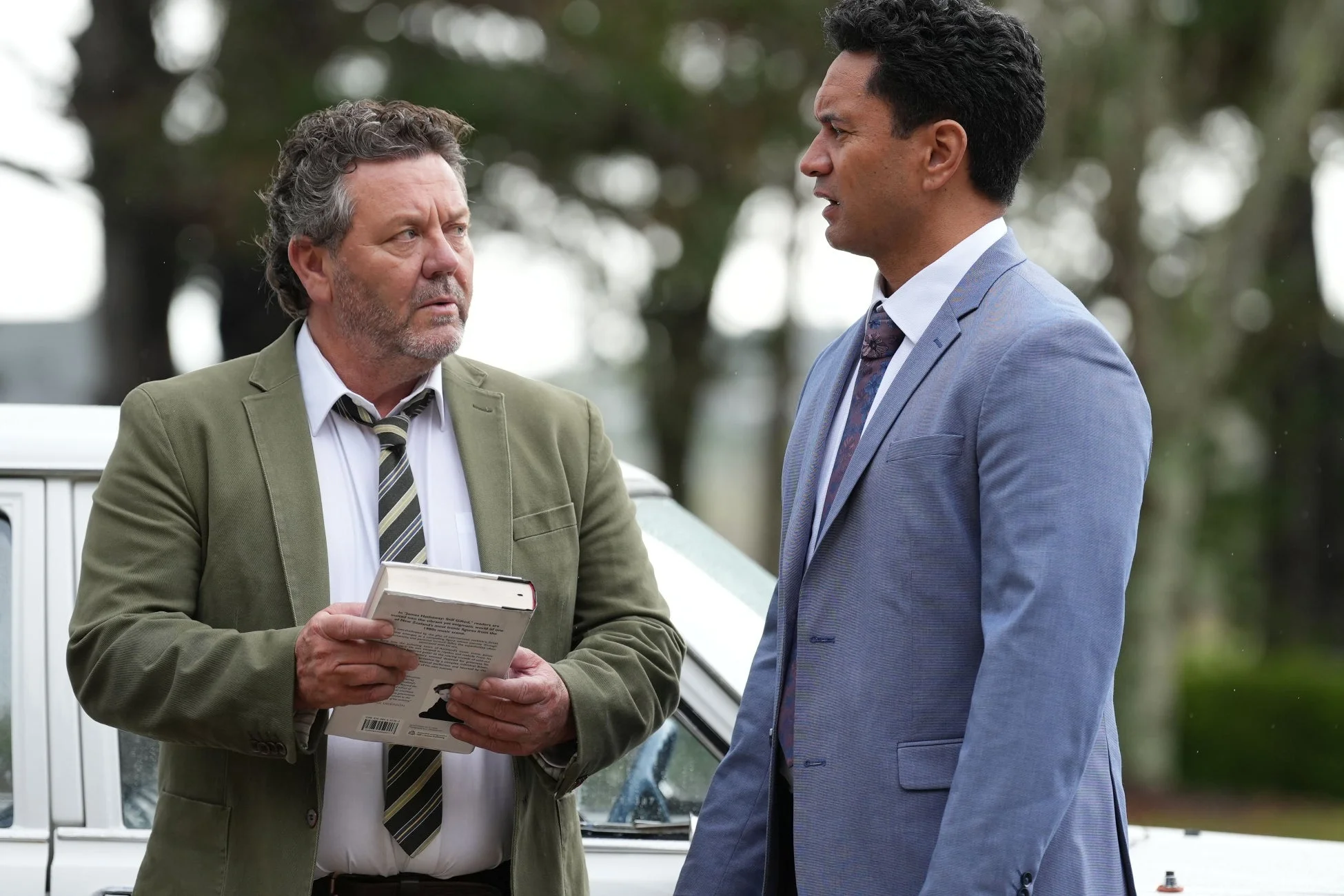 屋外で会話するスーツ姿の男性たち