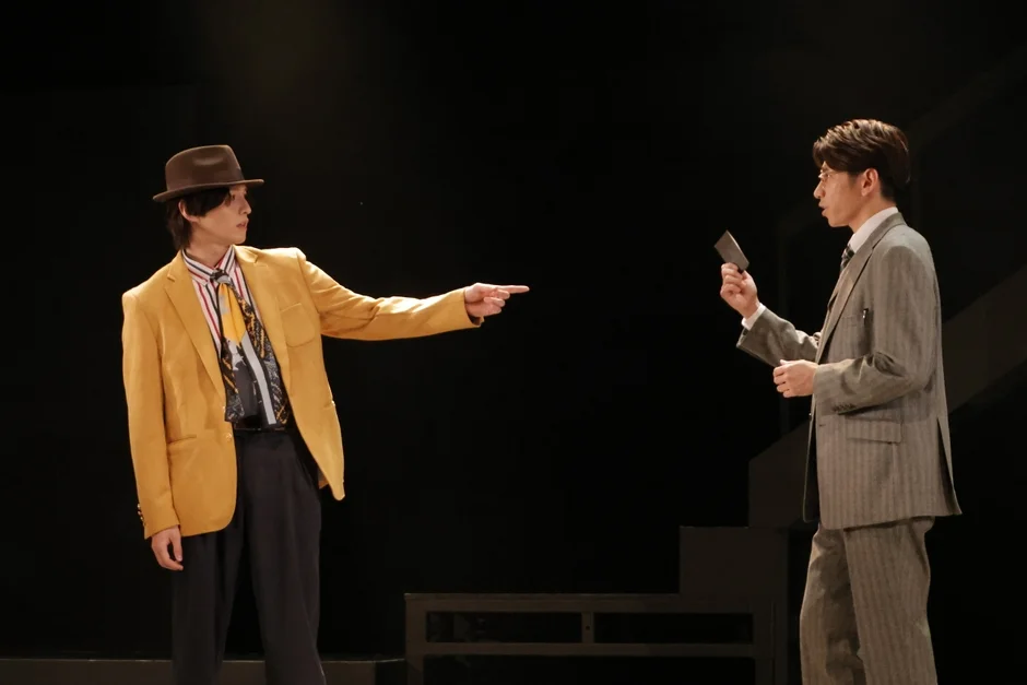 舞台上で対峙する2人の男性