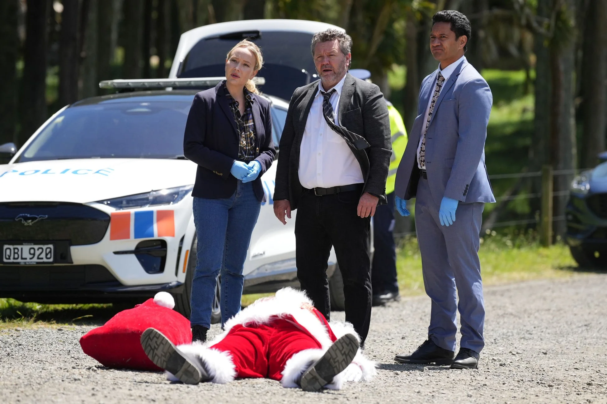 屋外の事件現場で捜査する刑事たち